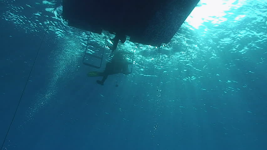 scuba diver under boat, under water view
