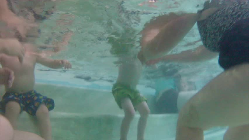 People swimming in a hotel swim pool underwater shot