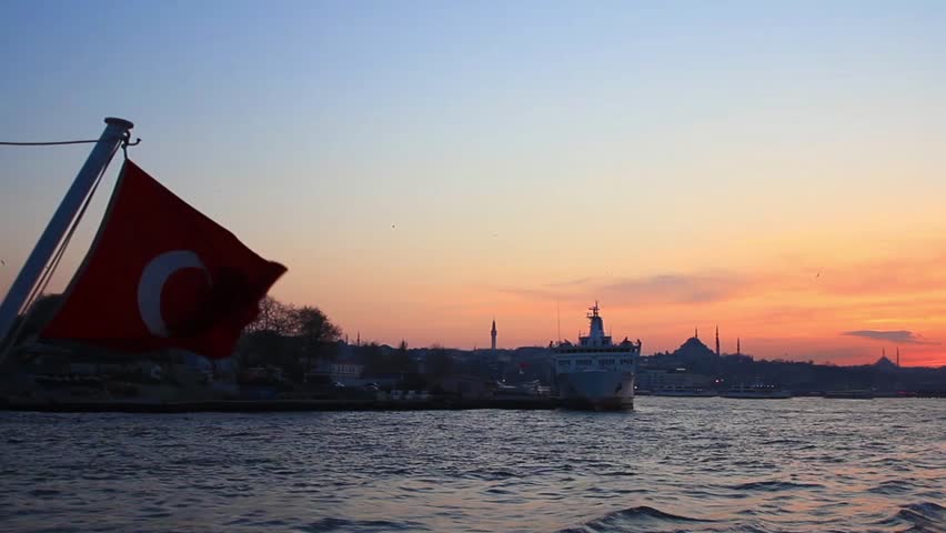 Ship sailing past the city of Istanbul. Turkish Flag waving in front of