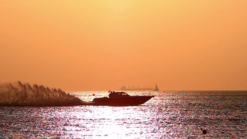 Power boat speeds at sunset. Tracking video. Race boat speeding up on the sea.
