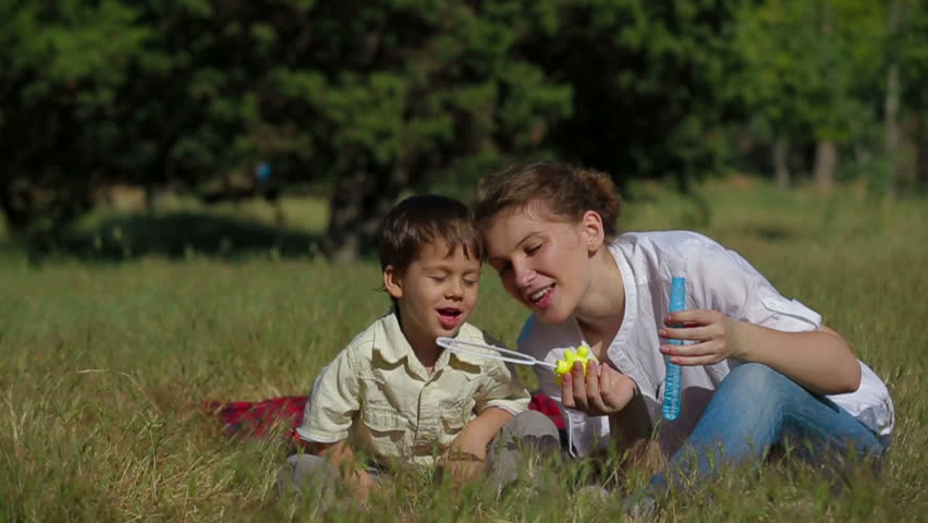 Young woman and her son are blowing bubbles in the park. Slow motion. | Shutterstock HD Video #4367795