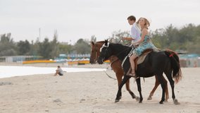 Couple is riding horses on the beach.