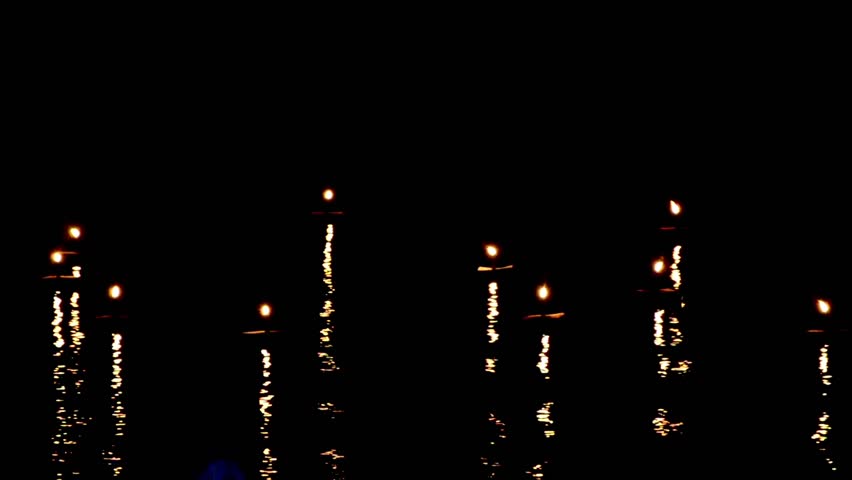 Candles lights move and wave with nice reflection on the water surface  in the