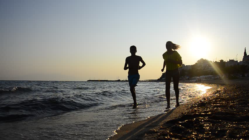 HD: Jogging In The Sunset. HD1080: Silhouette of a couple jogging by the seaside