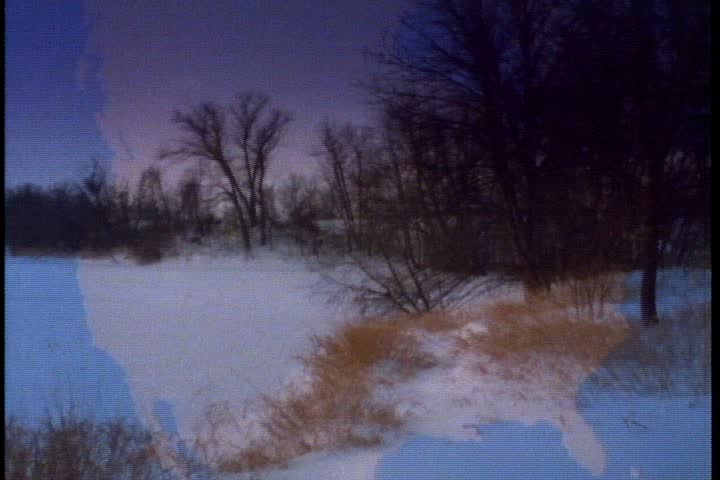 WS camera pans left over frozen pond under a purple winter sky in Minnesota.