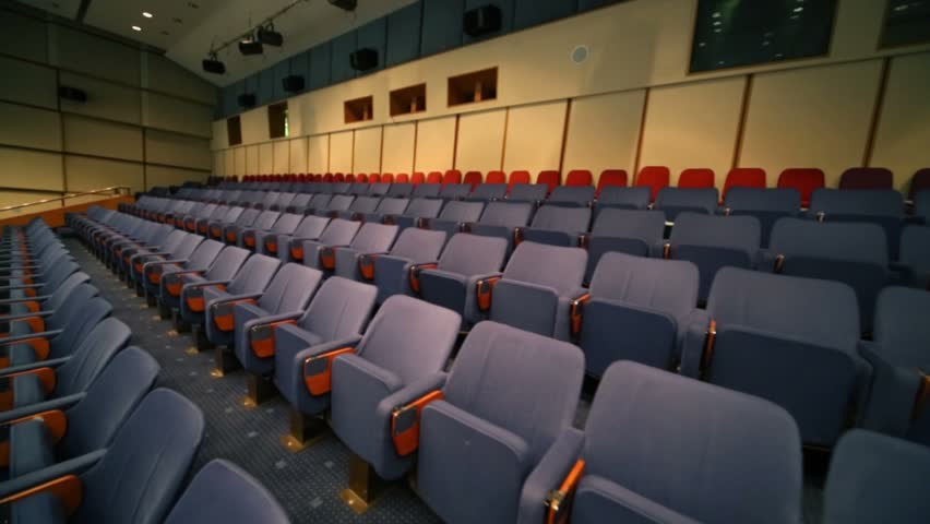 Conference room with rows of comfortable gray cloth seats