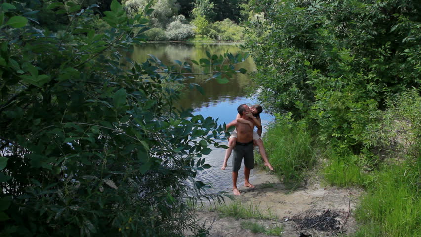 A love story. A man and a woman beautiful couple near the water on the shore of the rivers. Love and kisses.