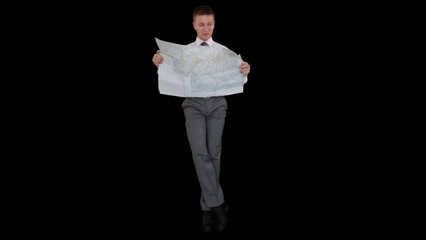Young businessman reading a map and sitting, against black