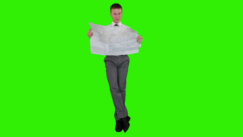Young businessman reading a map and sitting, Green Screen