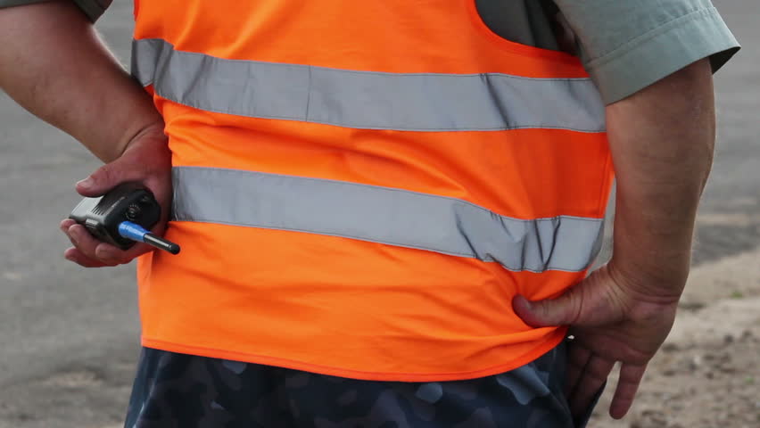 Clumsy fat male security with walky-talky in orange uniform