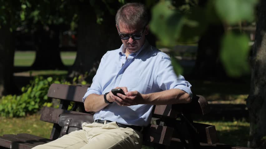 Casual businessman using smartphone outside
