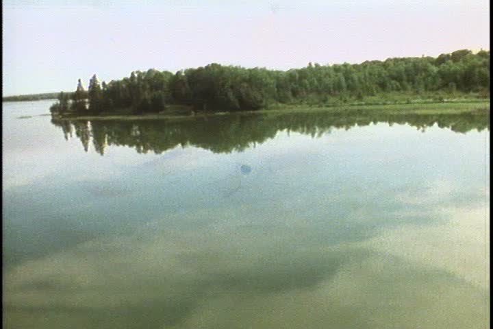  Aerial shot skimming over still river and treetops of Minnesota forest.
