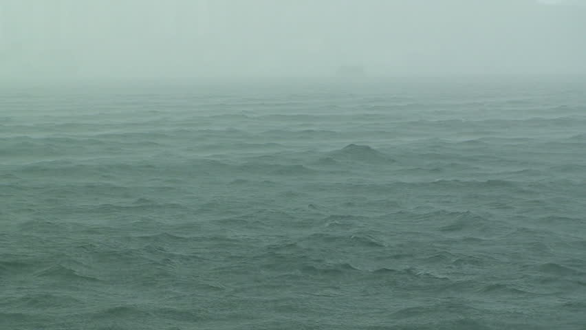 Heavy rain pours down on surface of the sea.
