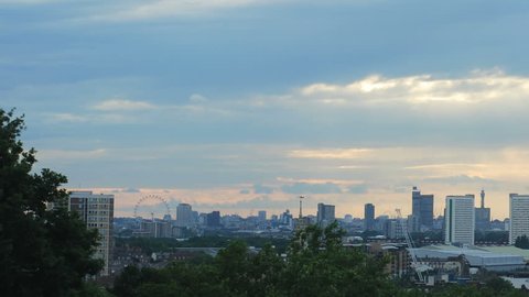 Time lapse slow pan across London city skyline at sunset including London Eye, Wembley Stadium, Nat West Tower and the Erotic Gherkin buildings