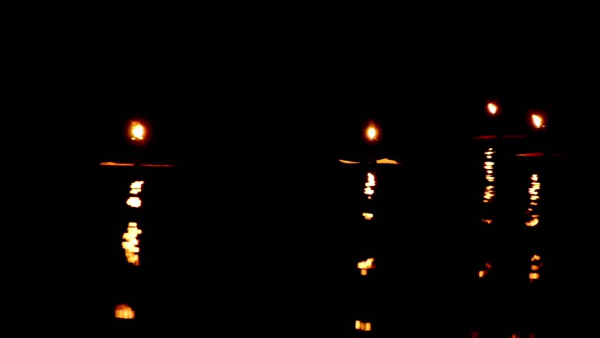 Dark background of Candles waving with nice reflection on water surface