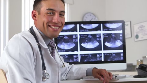 Latino doctor talking about sonogram on computer screen