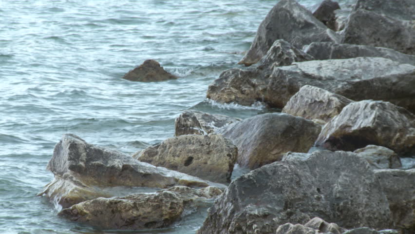 Close view of waves breaking on rocks at a breakwater.