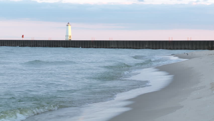 Dawn on the coast of Lake Michigan, looking along the beach to the lighthouse at