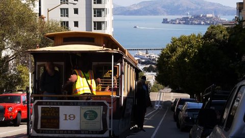 a san francisco cable car with alcatraz island in the background