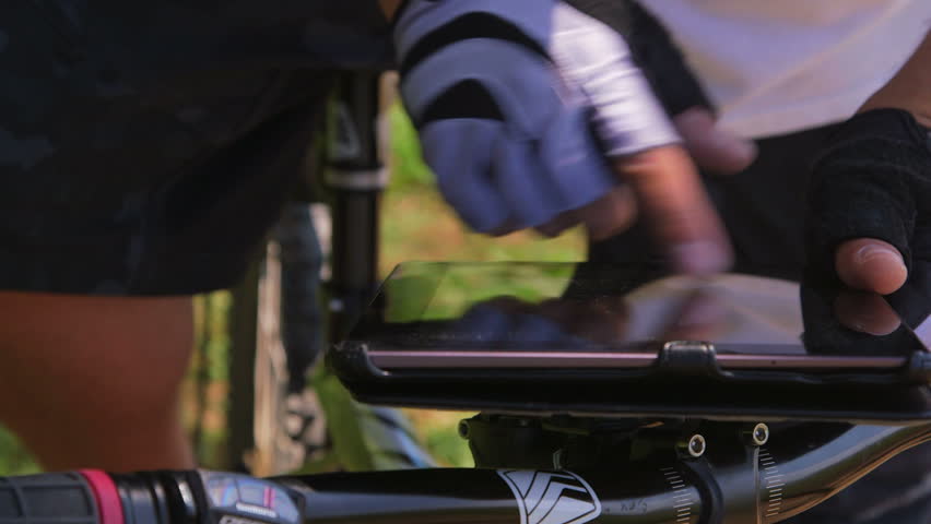 Mountain biker looking at digital tablet for GPS navigation