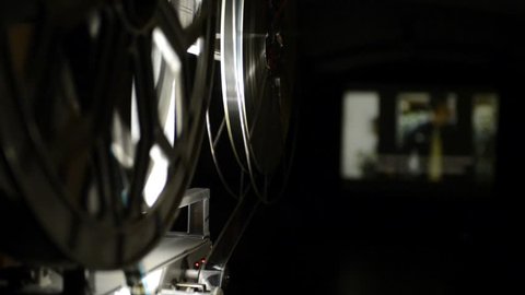 Old projector shows films in a movie theater.
