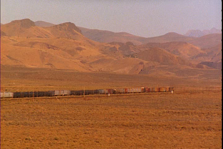 WS freight train moves through the Great Basin Desert, with mountains in background in Promontory, Utah.