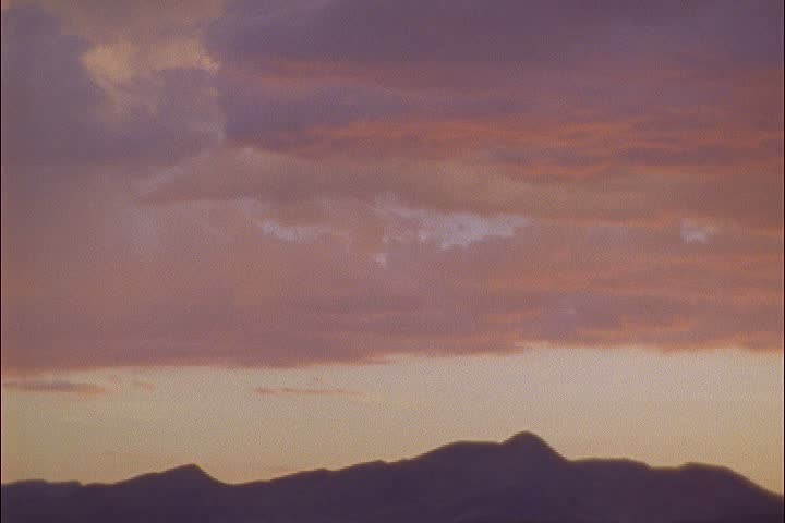 WS silhouettes of desert hills on horizon at sunset in Elko, Nevada. Camera pans right.