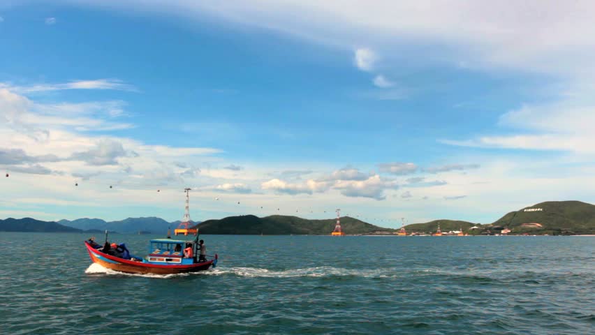 Motor boat in Nha Trang Bay on a background of cable car Vinpearl, Vietnam. This