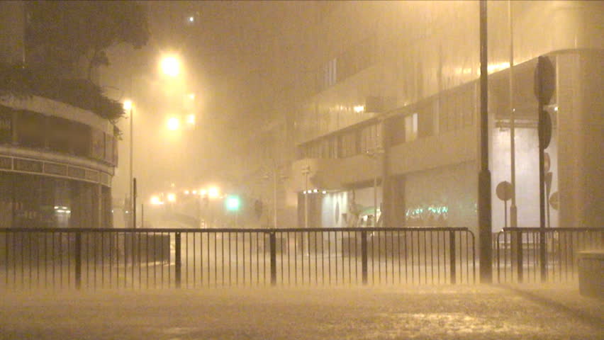 Torrential rain pours on city street at night