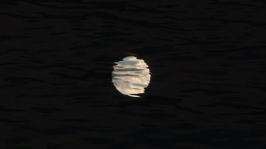 Full glowing moon reflected on water