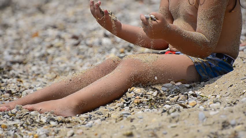 Toddler girl on beach. Cute little blonde girl playing on sandy beach. Lovely