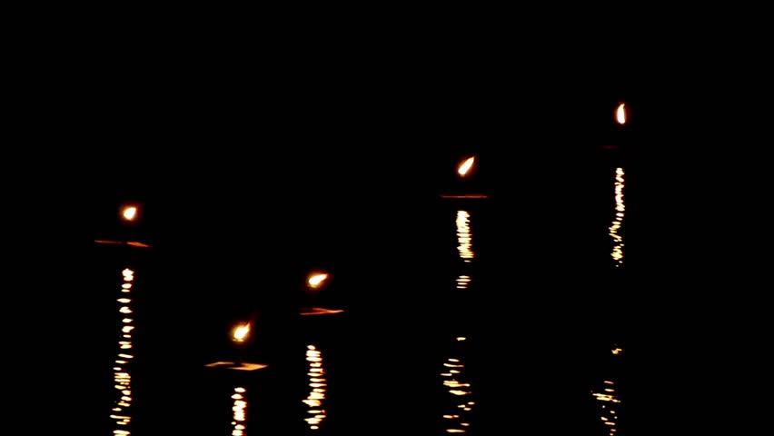 Candles lights move and wave with nice reflection on the water surface  in the