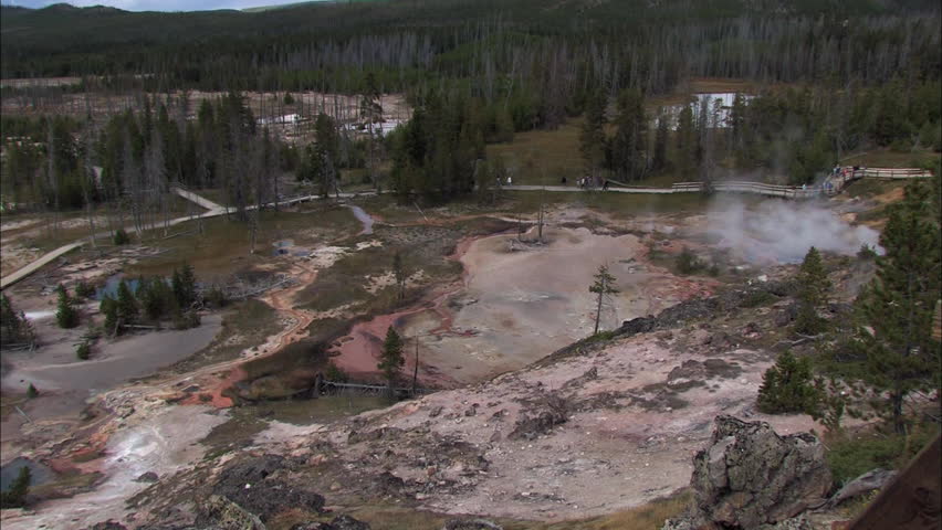 Aerial view of Yellowstone National Park with tourists and smoking geyser