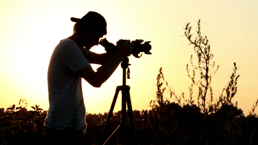 Photographer videographer shoots at dusk, camera viewfinder