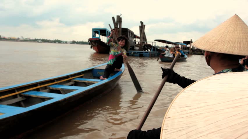 MEKONG DELTA, VIETNAM - JULY 24: woman rows a boat on a canal, Vietnam on July