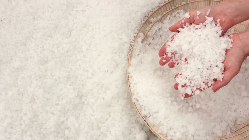 Close-up of huge salt crystals in the hands of a woman. Salt fields of Nha