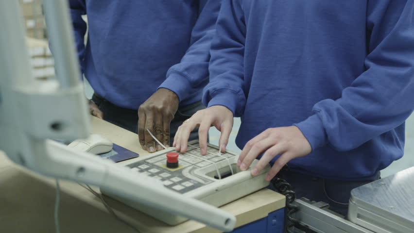 Cheerful mixed ethnicity factory workers looking at the VDU screen on one of the machines. Royalty-Free Stock Footage #4402145