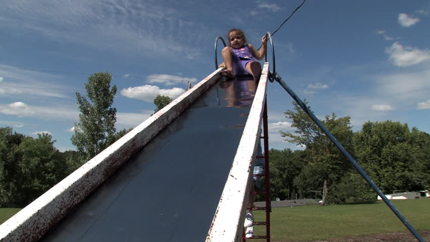 A young girl slides down a sliding board.