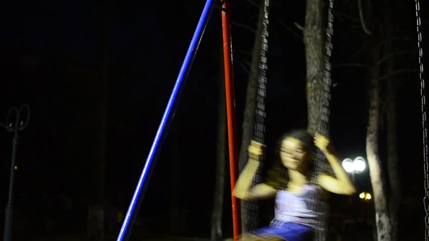 Young girl on swing LOOP. Young girl swings at night