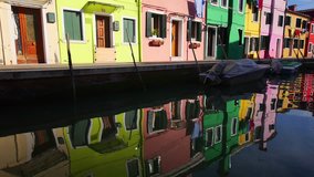 Burano island, Venice, Italy. Multicolored houses and their reflection in water.