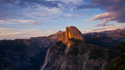 a panning time lapse shot of the sun setting on half dome at yosemite recorded from glacier point