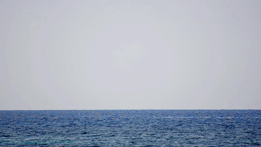 Sailboat in regatta on blue sea water surface horizon