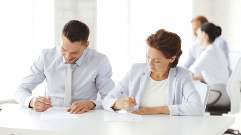 business and office - man and woman signing a contract