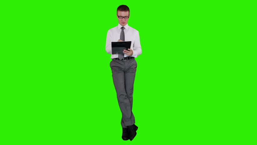 Young businessman with glasses writting on a clipboard and sitting, Green Screen
