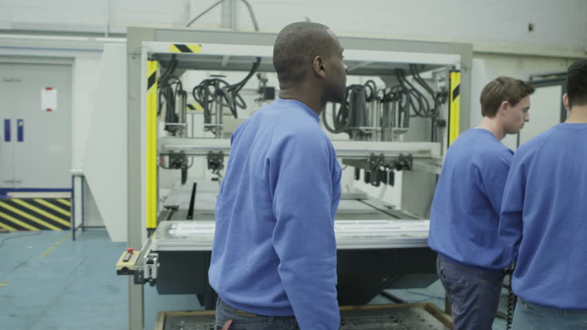 Cheerful mixed ethnicity factory workers looking at the VDU screen on one of the machines. Royalty-Free Stock Footage #4417589