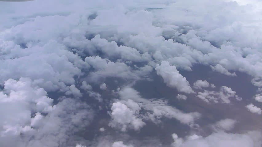 Cloudscape aerial while flying above storm clouds and flight attendant