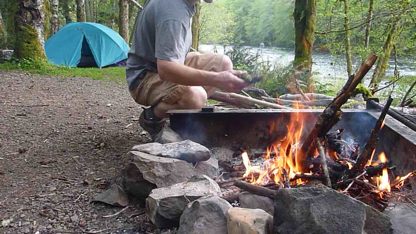 Man and campfire at camp in the Pacific Northwest, Oregon.