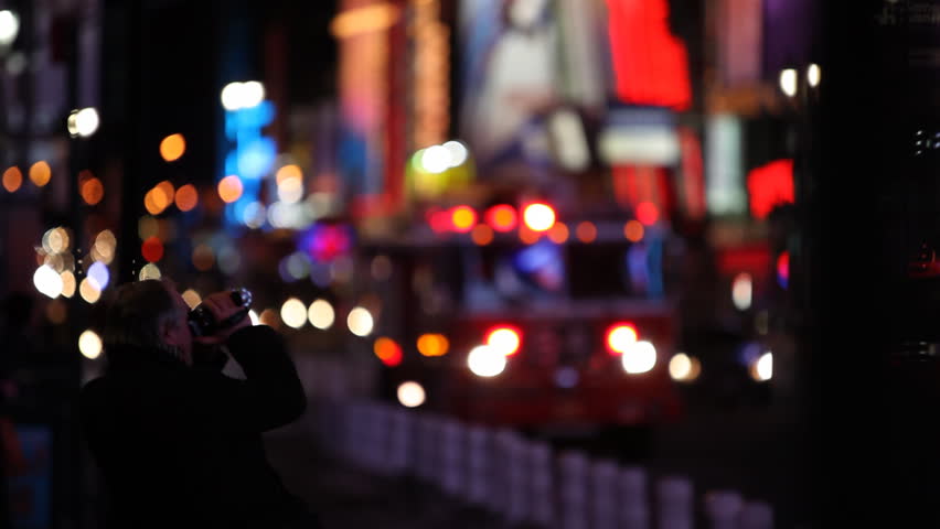 A man filming the Times Square with a small video cam (lighter in original) /