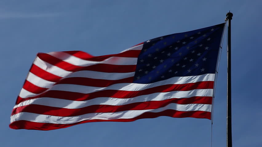 USA, american flag in the wind with blue sky as background / HD1080 / 29.97fps
