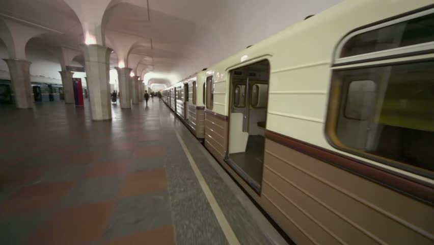 Policemen and people walk by platform near retro suburban train at dark station